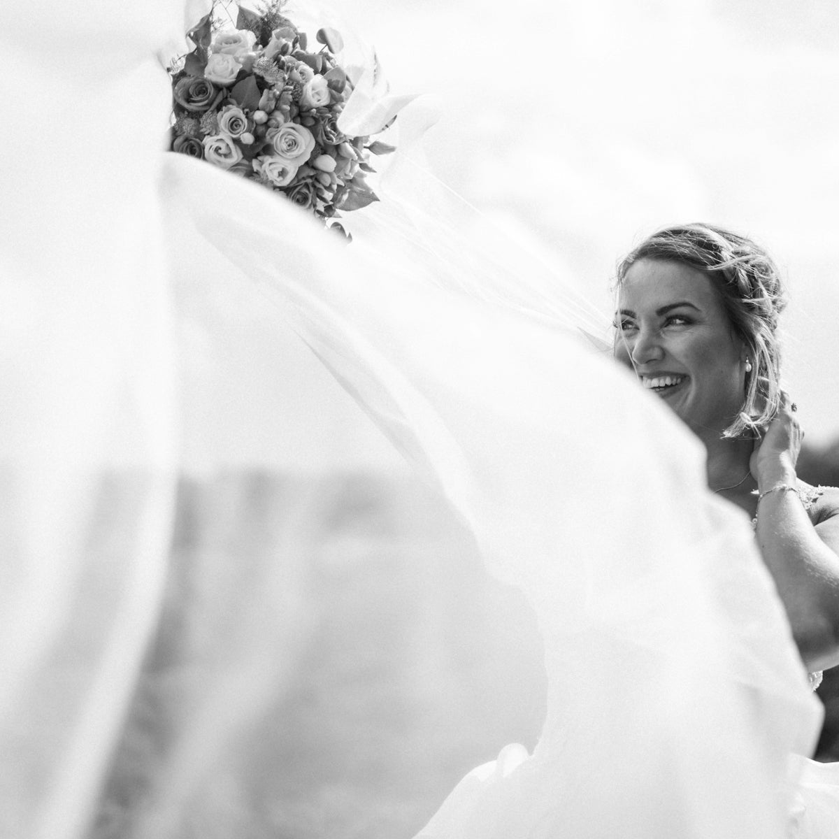 a woman in a wedding dress holding a veil